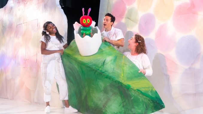 Three actors and a caterpillar puppet